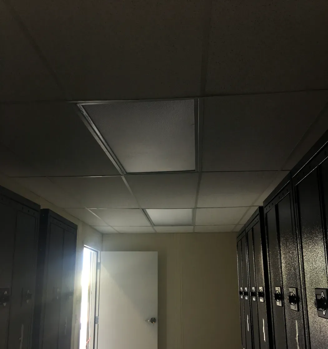 Finished modular change room interior with employee lockers, lay-in ceiling and steel door at Stork in Salt Lake City