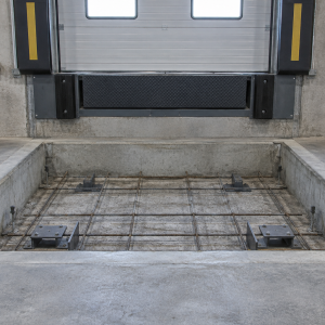 Fabricated shallow pit, 24 in. minimum depth, cast into a warehouse dock floor for a fully automatic loading ramp/dock leveler installation