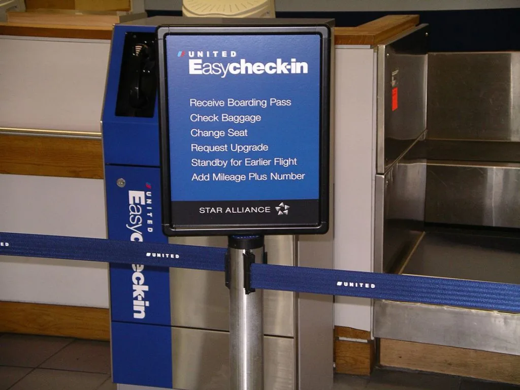 Airport check-in queue with a Visiontron post-top sign frame and branded retractable belt