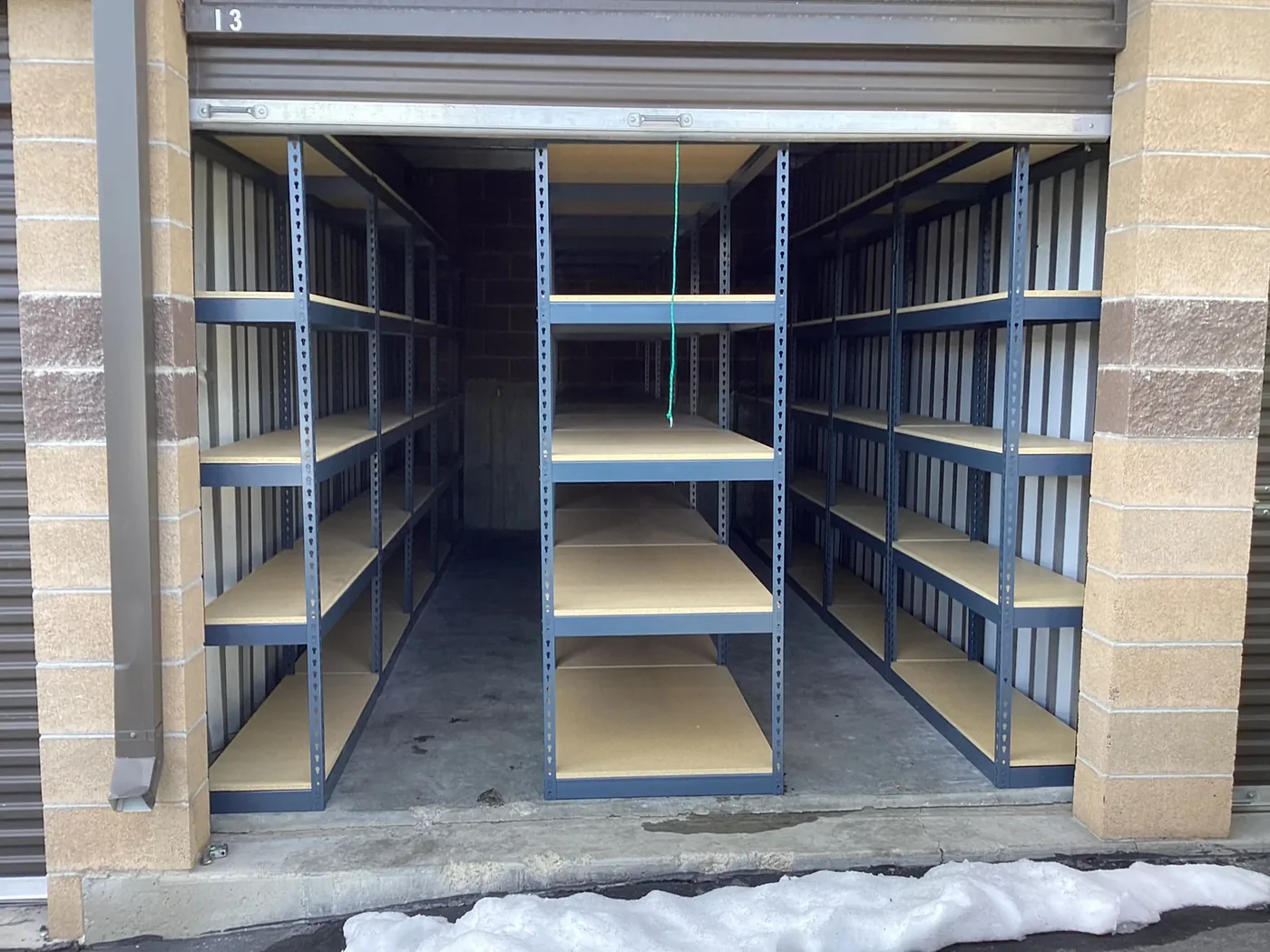 New boltless rivet shelving installed inside a self-storage unit in Lehi, Utah, viewed from the roll-up door