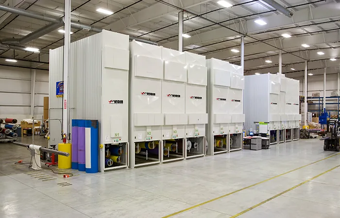 Bank of enclosed Vidir Hollow Core Carousels lined up along a plant wall with sleeve storage openings at floor level