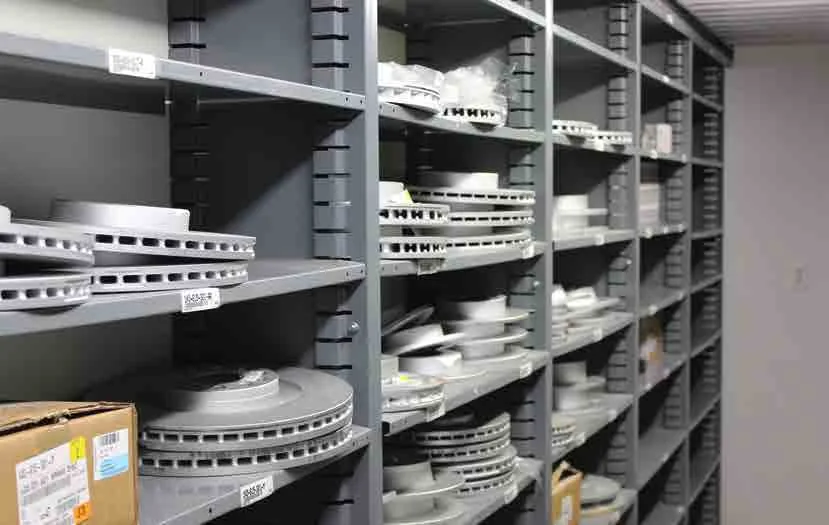 Gray Borroughs Flexi-Bin open shelves stacked with brake rotors in a parts room