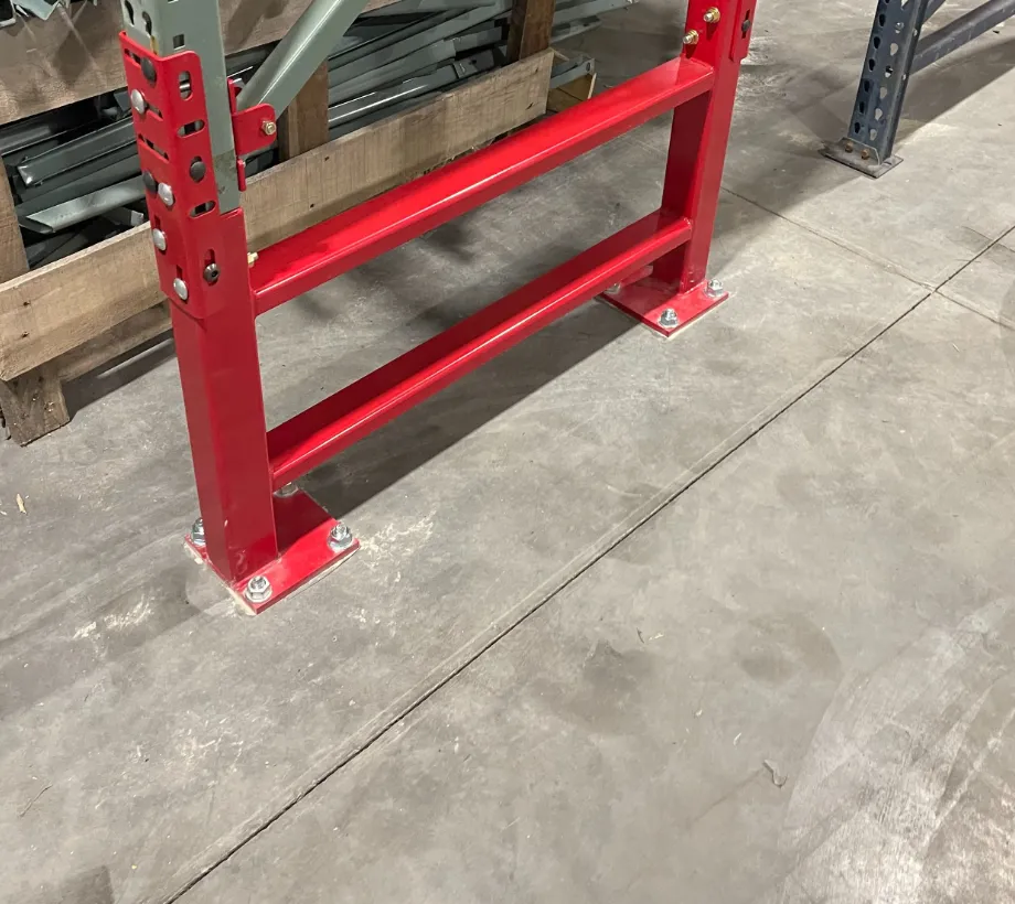 Red Centurion Row Guard frame anchored to the floor across the front and rear rack uprights