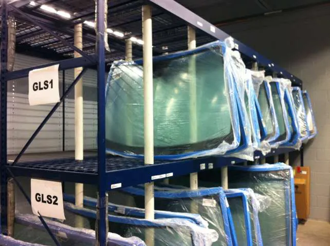 Windshields stored upright in labeled Equipto V-Grip bulk rack bays in a dealer parts department