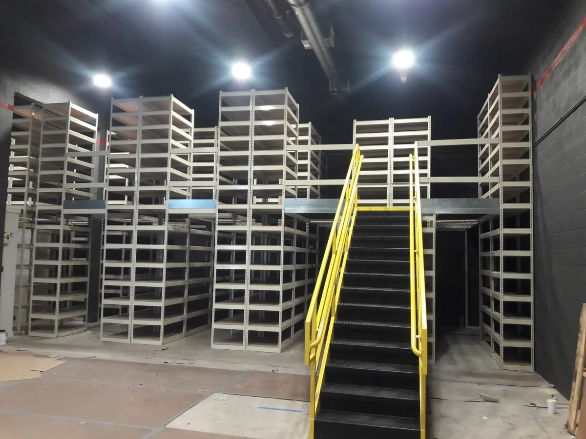 Two-level Hallowell Rivetwell boltless shelving system with a walkway deck and yellow stairs