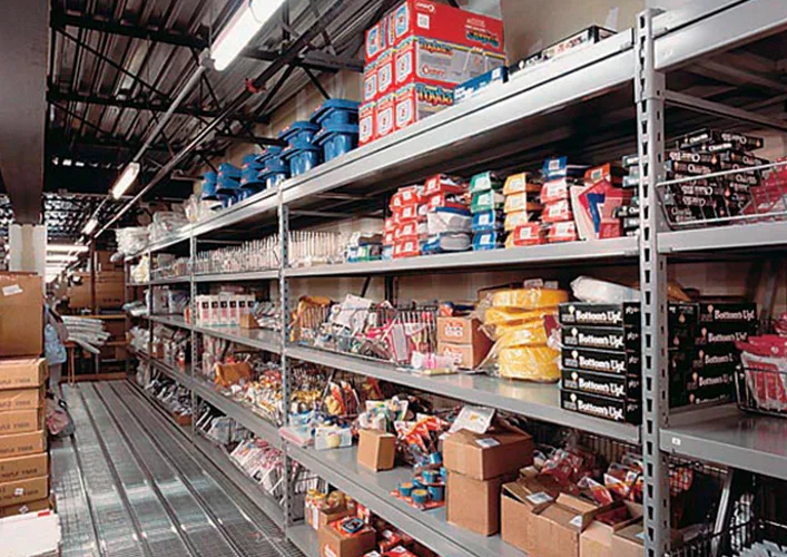 Aisle of Penco wide span heavy duty shelving loaded with boxed parts, cable reels and supplies on steel decks