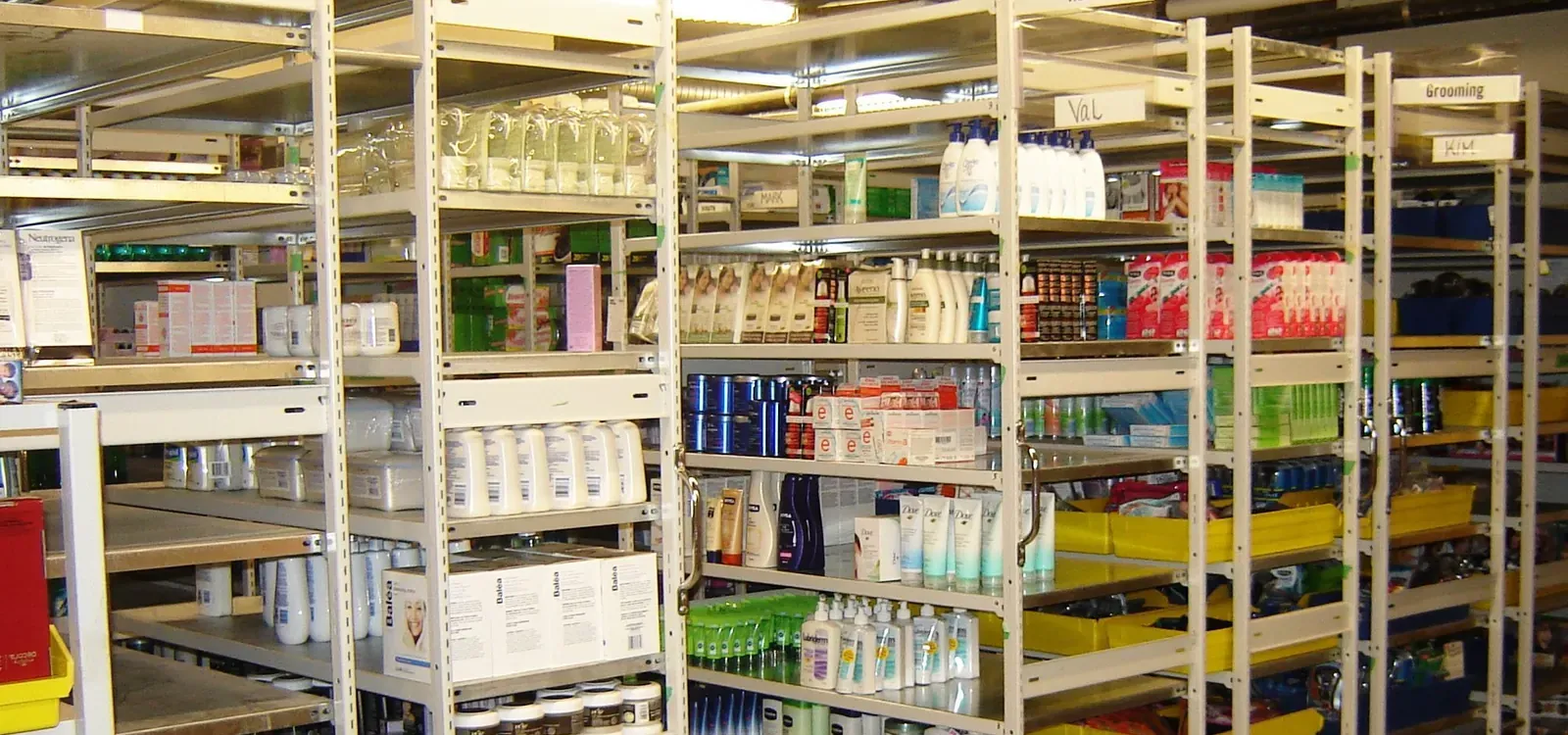 High-density shelving with labeled sections and yellow bins sorting patient care supplies by category