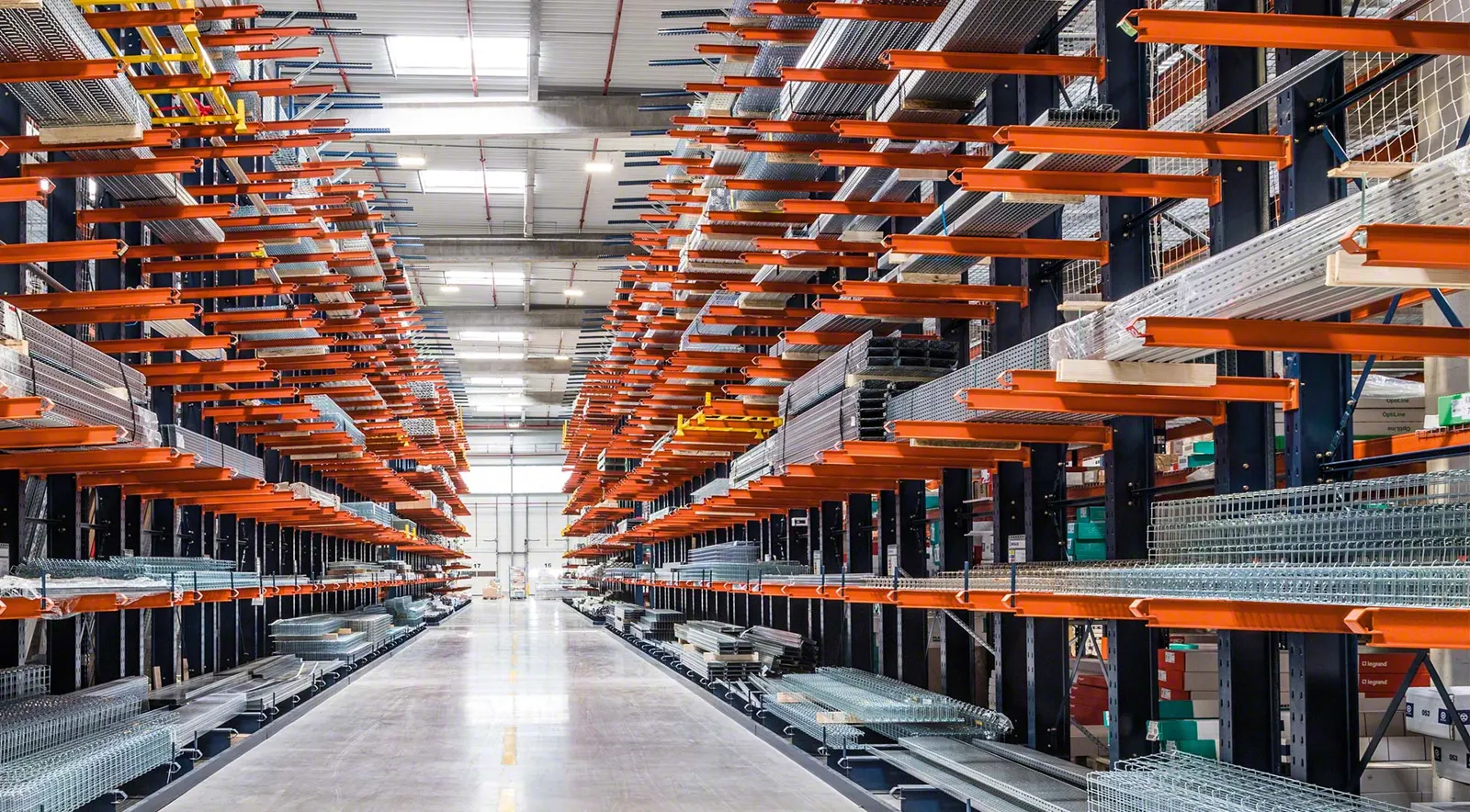 Long aisle of Interlake Mecalux cantilever racking with orange arms holding metal profiles