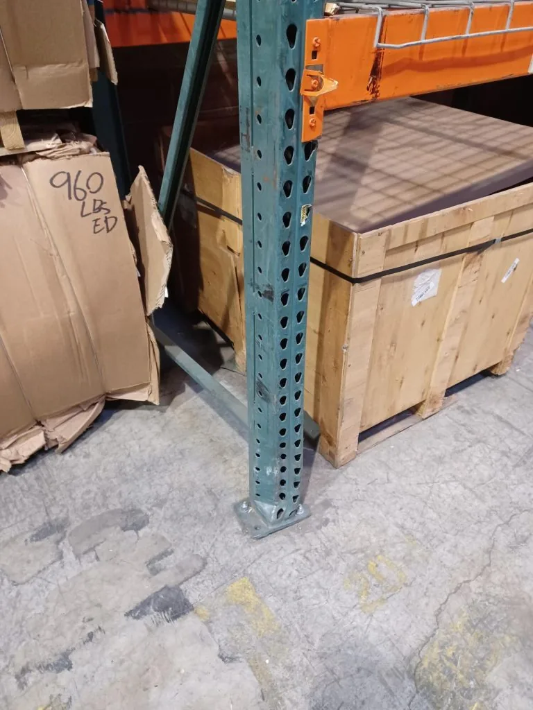 Impact-damaged pallet rack upright and baseplate at Motion Industries before repair
