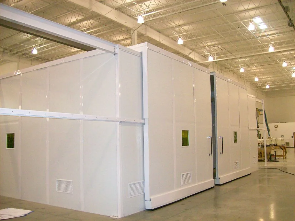 Large white modular room with tall wall panels inside an industrial building
