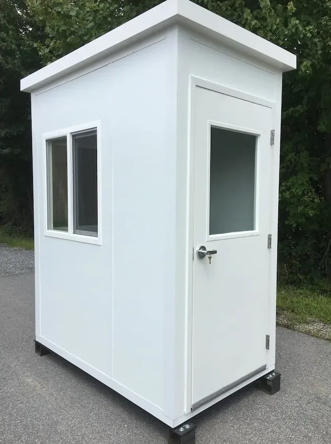 White quick-ship prefabricated booth with a sliding window, half-glass steel door and flat roof on skids