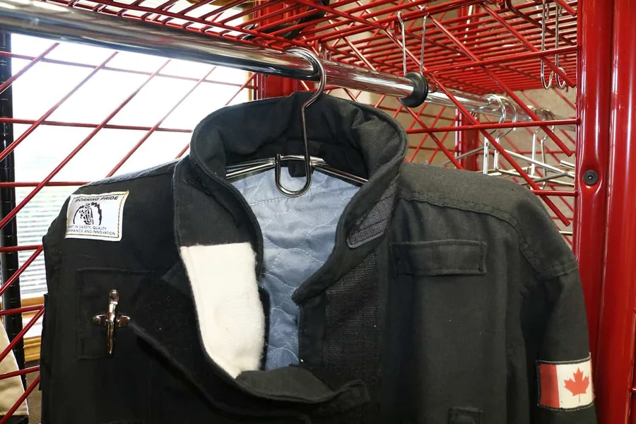 Dry Kwik open-loop hanger spreading a turnout coat open inside a Red Rack locker
