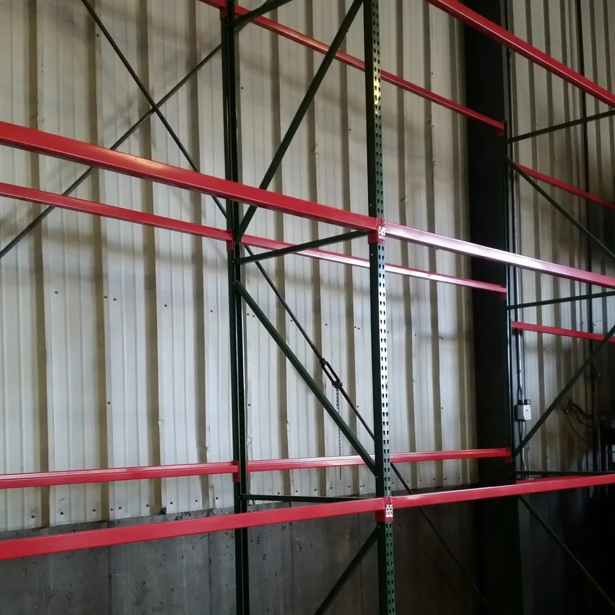 Newly installed tall green upright frames and red step beams at the Sapp Bros travel center tire area in Salt Lake City