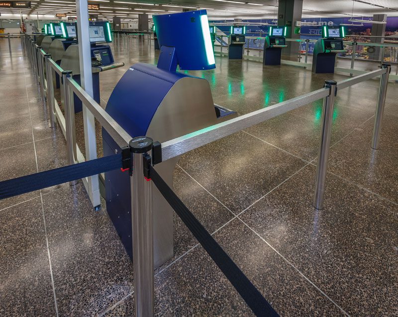 International arrivals hall with socket-mounted stainless posts joined by belts and top beams