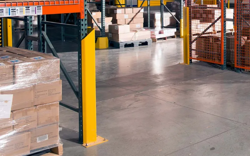 Yellow SpaceGuard AisleGuard rack guard protecting a pallet rack upright at an aisle corner