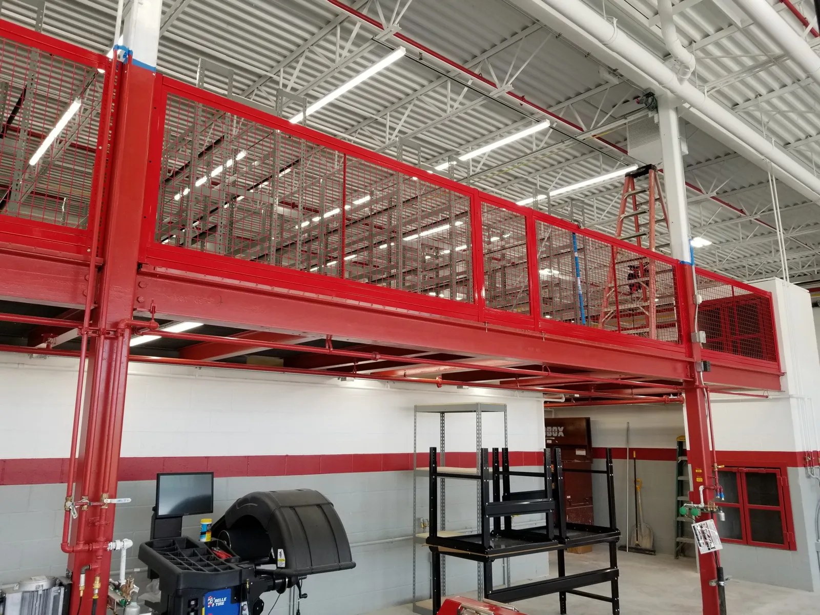 Red BeastWire mezzanine railing with wire mesh infill panels on an elevated platform edge