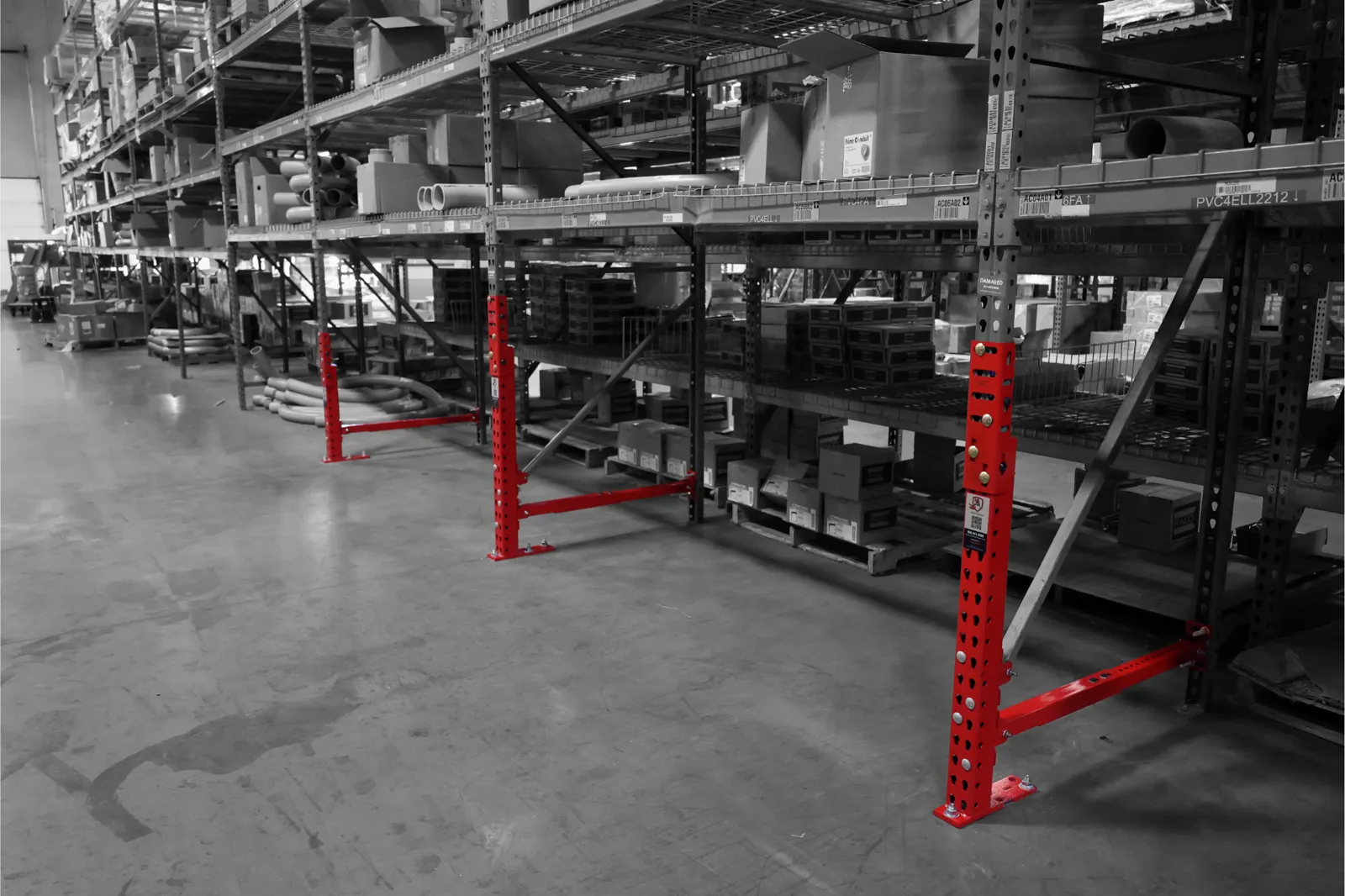 Three red SpaceGuard Centurion Mid Guard repair kits with bracing installed along a pallet rack row