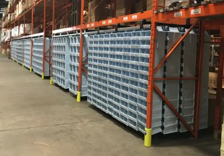 Storeganizer pick faces: textile pocket columns hanging in a long run of pallet rack bays