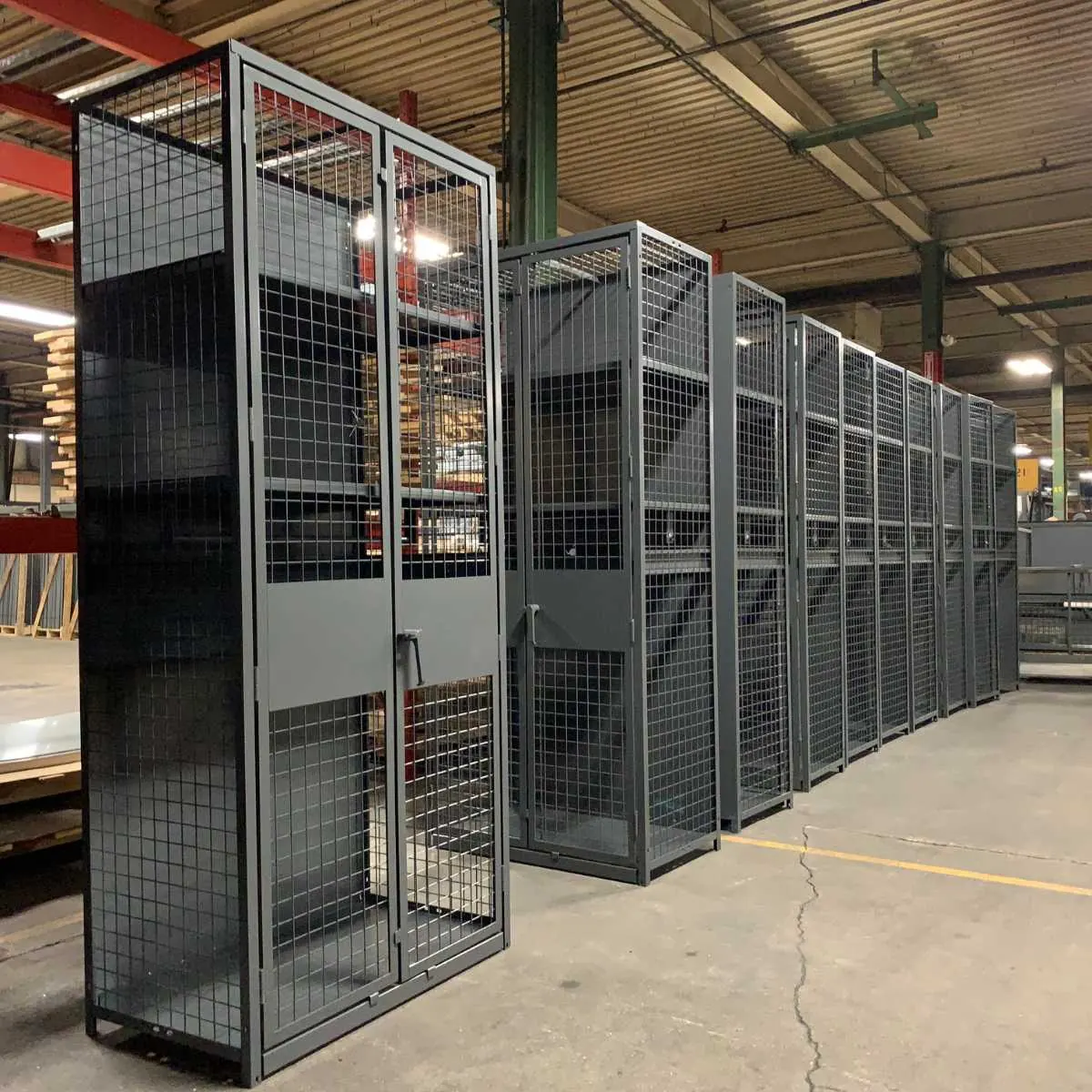 Row of gray TA-50 military gear lockers with wire mesh fronts and double doors
