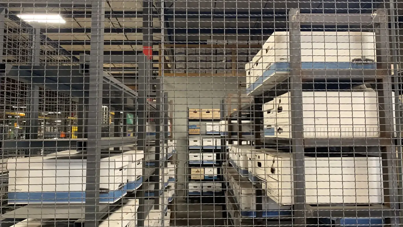 Wire mesh evidence storage lockers with shelves holding evidence boxes