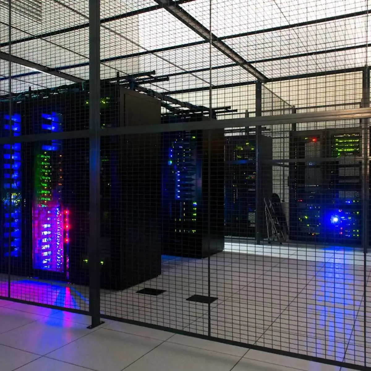 Wire mesh server cage enclosing lit server racks